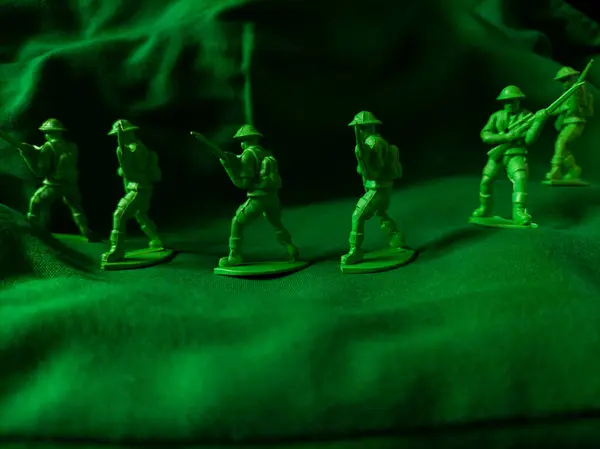 Yeşil kumaş arka planında yeşil plastik ordu oyuncağı