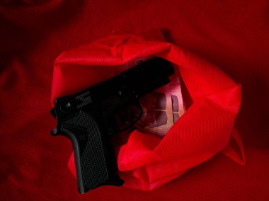 Kırmızı desenli kumaşta oyuncak silah.