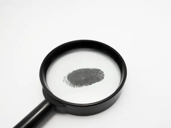 Beyaz bir yüzeyde parmak izi olan siyah saplı bir büyüteç.