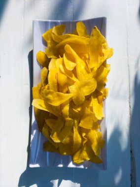 Beyaz ahşap arka planda sarı muz cipsi