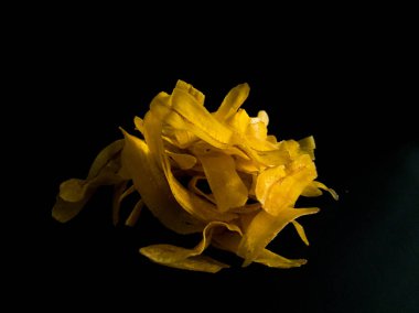 Siyah bir yüzeyde sarı muz cipsi