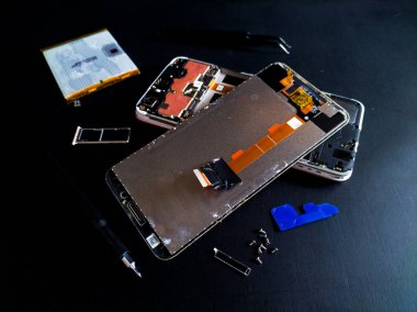 Siyah arkaplanda bir cep telefonu onarımı