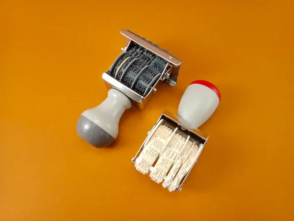 Açık kahverengi arka planda iki kauçuk tarih damgası