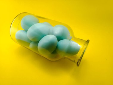 Açık mavi yumurtalar cam bir kavanozun içinde.