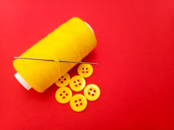 Kırmızı arkaplanda dikiş malzemeleri