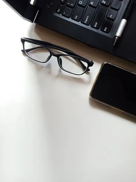 Gözlükler ve dizüstü bilgisayarlar beyaz masada