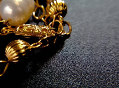 Koyu arkaplanda altın bileziği kapat