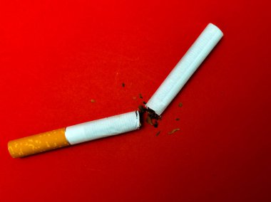 Kırmızı arka planda kırık sigara, sigara içmeyi bırak.
