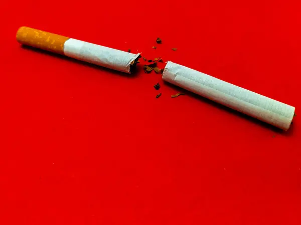 Kırmızı arka planda kırık sigara, sigara içmeyi bırak.