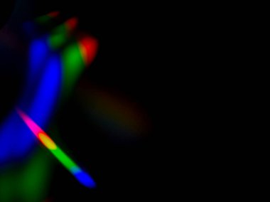 Karanlık bir arkaplana karşı soyut renkli ışık izlerinin görüntüsü.