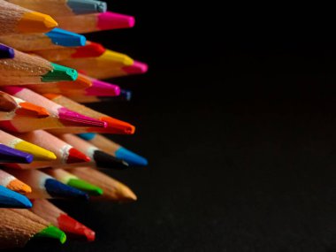 Siyah arkaplanda renkli kalemlerin yakın plan görüntüsü