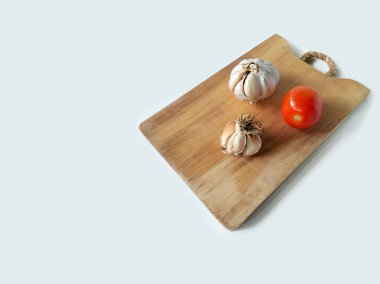 Sarımsak ve domatesler doğrama tahtasında