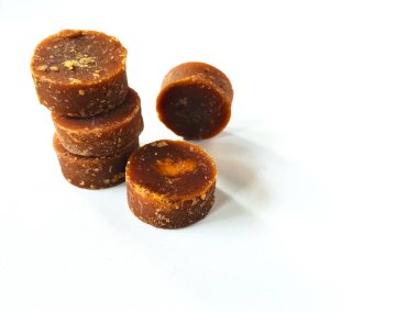 Yuvarlak kahverengi şeker parçaları beyaz bir yüzeye dizilmiştir.. 