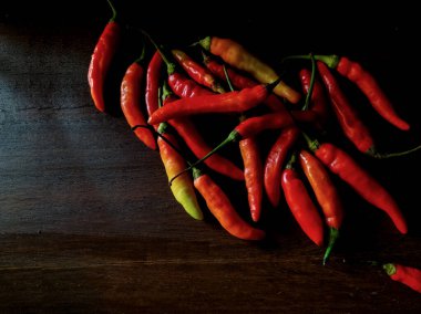 Kırmızı biberler koyu ahşap bir yüzeye dizilir.. 