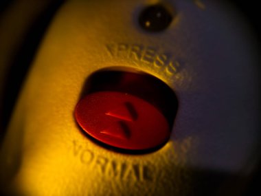 Sol ve sağ tarafı işaret eden kabartmalı okları olan kırmızı oval şekilli bir düğmeye yakın plan.. 