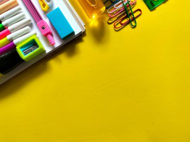 Sarı arka planda çeşitli okul malzemeleri var. Okul konseptine dönelim..