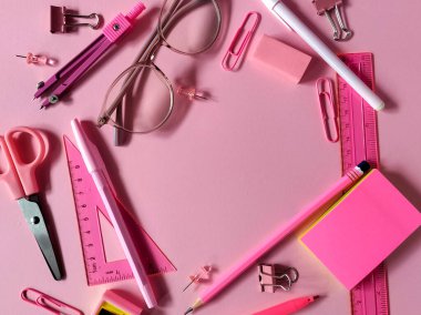 okul malzemeleri ve pembe arkaplan üzerine kırtasiye malzemesi