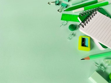 Yeşil bir yüzeye yerleştirilmiş okul malzemeleri koleksiyonu. Okula geri dön.