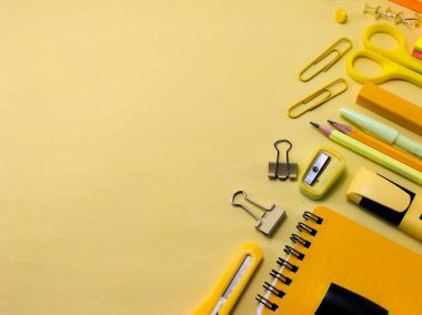 Sarı bir yüzeye yerleştirilmiş okul malzemeleri koleksiyonu. Okula geri dön.