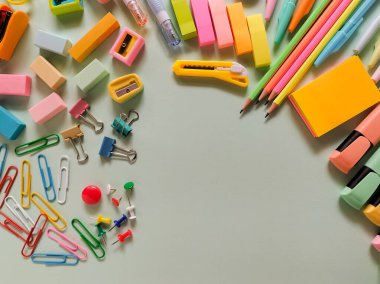 Açık yeşil bir yüzeye yerleştirilmiş çeşitli okul malzemeleri.. 