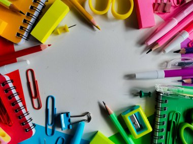 Daire şeklinde dizilmiş rengarenk okul malzemeleri. 