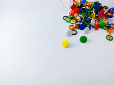 Renkli bir raptiye ya da raptiye koleksiyonu açık bir yüzeye saçılmıştır. 