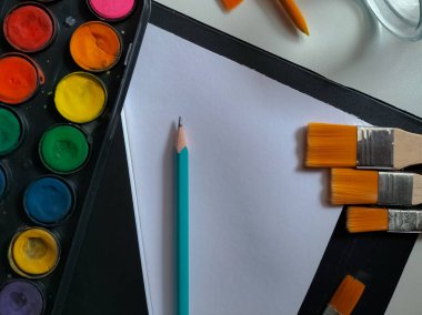 Beyaz arkaplanda suluboya boya ve fırça seti