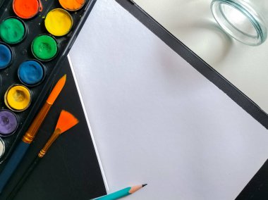 Beyaz arkaplanda suluboya boya ve fırça seti