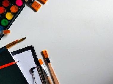 Beyaz arkaplanda suluboya boya ve fırça seti