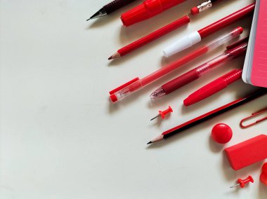 Kırmızı okul malzemeleri beyaz bir yüzeye yerleştirildi..