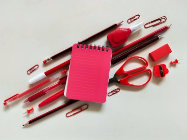 Kırmızı okul malzemeleri beyaz bir yüzeye yerleştirildi..