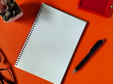 Turuncu arka planda minimal çalışma alanı kurulumu. 