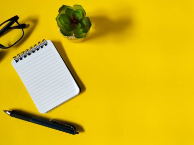 Parlak sarı arkaplanda minimal çalışma alanı kurulumu. 