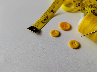 Beyaz arka planda sarı dikiş aksesuarları koleksiyonu. 