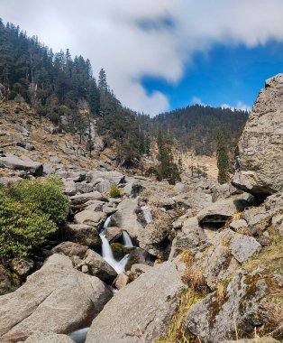 Güzel bir şelale Kareri, Dharamshala, Himachal Pradesh, Hindistan 'daki bazı kayaların arasından akıyor.