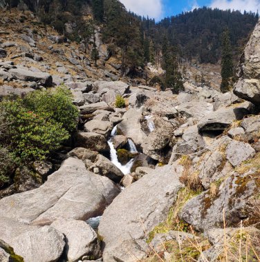 Güzel bir şelale Kareri, Dharamshala, Himachal Pradesh, Hindistan 'daki bazı kayaların arasından akıyor.