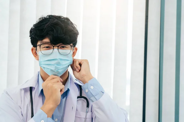事務所でマスクをしたアジア系男性医師 — ストック写真