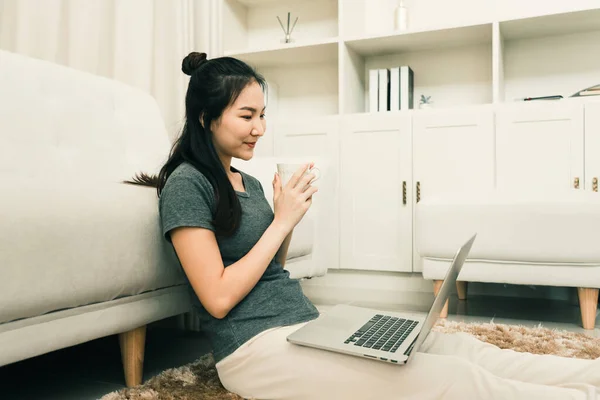 Asiatisk Kvinna Sitter Vardagsrummet Med Kaffekopp Och Bärbar Dator Knät — Stockfoto