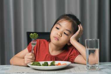 Küçük tatlı kız sağlıklı sebze yemeyi reddediyor. Çocuklar sebze yemeyi sevmez..