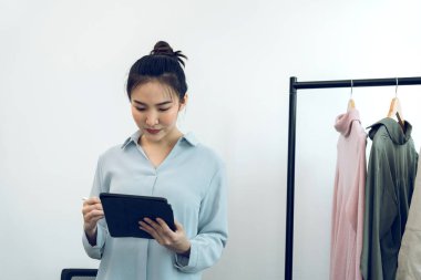 Genç Asyalı girişimciler online satın alma siparişlerini kontrol ederken bir tablet kullanıyorlar.