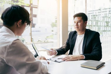 Erkek müdür çalışana istifa mektubu dağıtırken çalışanın işten çıkarılması hakkında konuşuyor ya da açıklama yapıyor..