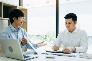 İş adamı iş arkadaşlarına raporunda mali bütçe rakamlarını açıklıyor.