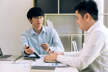 Businessman explaining to colleagues a graph of financial budget figures in a tablet.