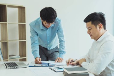 İki işadamı şirket gelirlerini masalarında analiz ediyor..