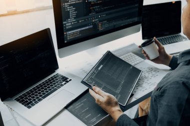 Sabah iş adamlarıyla çalışmak, yazılım geliştiricileriyle çalışan kahveyi bilgisayardaki programdaki kodu analiz etmek için bandırıyor..