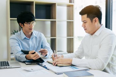 İş adamı meslektaşlarına tabletteki mali bütçe rakamlarının grafiğini açıklıyor.