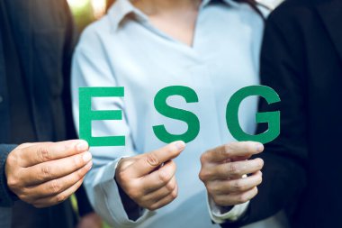 ESG metni, çevre, sosyal ve kurumsal yönetim kavramını elinde tutan iş adamlarının elleri.