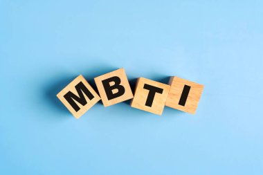 Mavi arka planda MBTI harfleri olan tahta bloklar. Kişilik tipolojisi. İnsan tipi için psikoloji testi. MBTI - Myers-Briggs Tip Göstergesi.