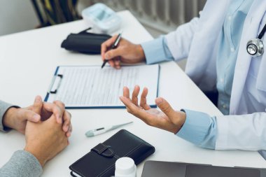 Doktorlar salgın sırasında maske takan bir hastanın hastalığının tedavisini açıklıyorlar..