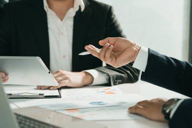 Grafik şirketinin mali bütçe raporunu analiz etmek için tablet kullanan iş ortaklığı iş arkadaşları ve ofis odasında gelecek için maliyet çalışması ilerleme ve planlama.